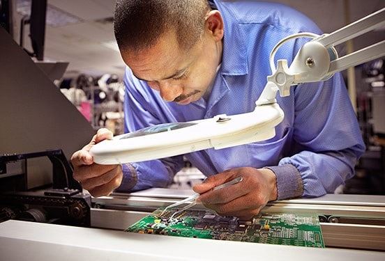 kohler employee doing meticulous quality control on home generator circuitry during manufacturing process